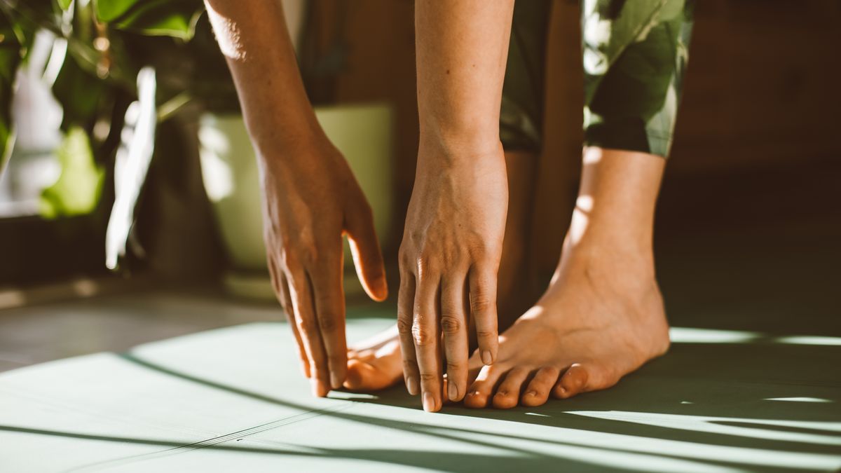 Chaussettes de yoga antidérapantes posées sur un tapis de yoga dans une pièce lumineuse