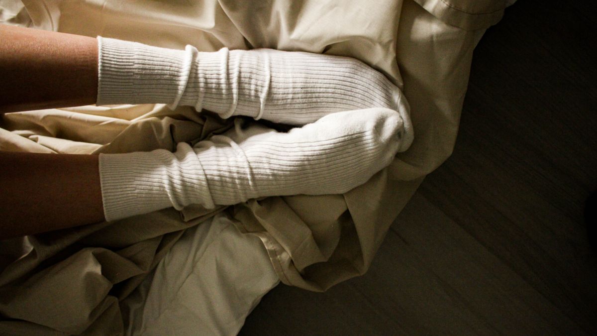 Comment enfiler des chaussettes de contention facilement : jambes en chaussettes au bord du lit le matin