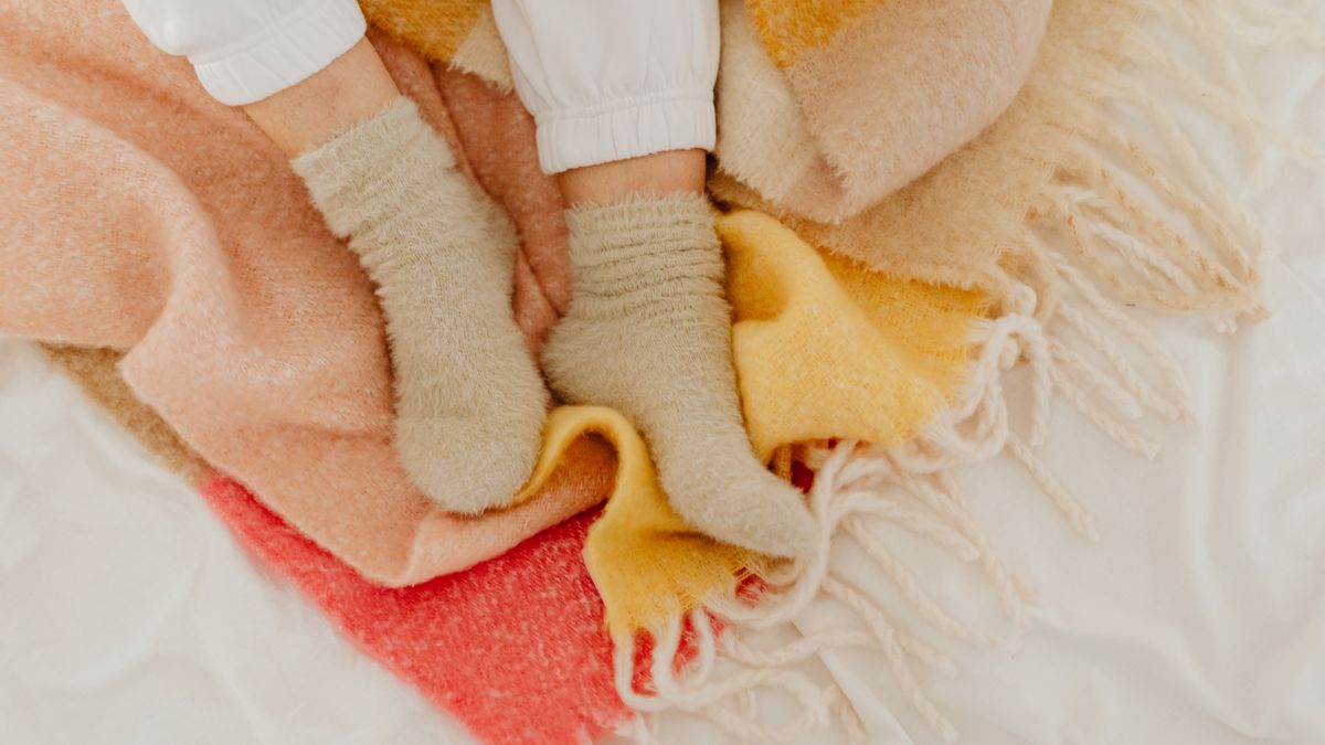 Chaussettes polaires et chaussettes pilou-pilou posées sur une couverture douce